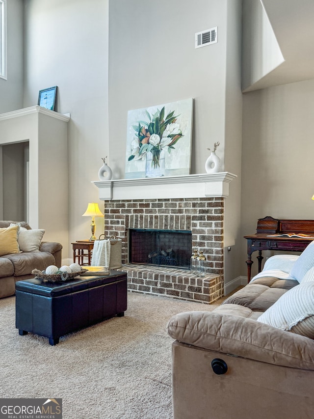 carpeted living room featuring visible vents, a fireplace, and a towering ceiling