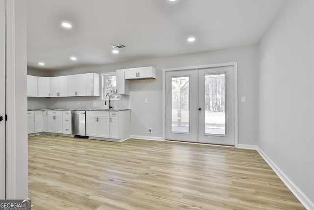 kitchen with white cabinets, french doors, and light hardwood / wood-style floors