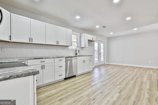 kitchen with light hardwood / wood-style floors, backsplash, dishwasher, white cabinets, and sink