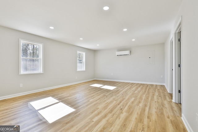 spare room with light hardwood / wood-style flooring and a wall mounted air conditioner