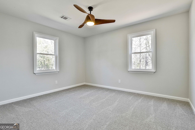 spare room with ceiling fan, carpet, and a wealth of natural light