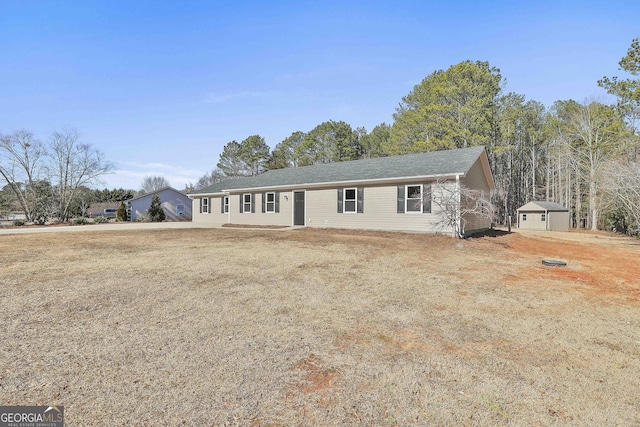 ranch-style house featuring a front yard and a storage shed