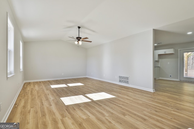 unfurnished room with ceiling fan, a wealth of natural light, lofted ceiling, and light hardwood / wood-style flooring