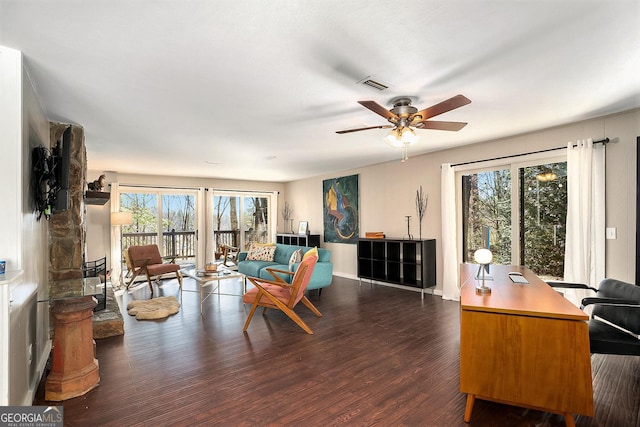 living room with ceiling fan, plenty of natural light, and dark hardwood / wood-style floors