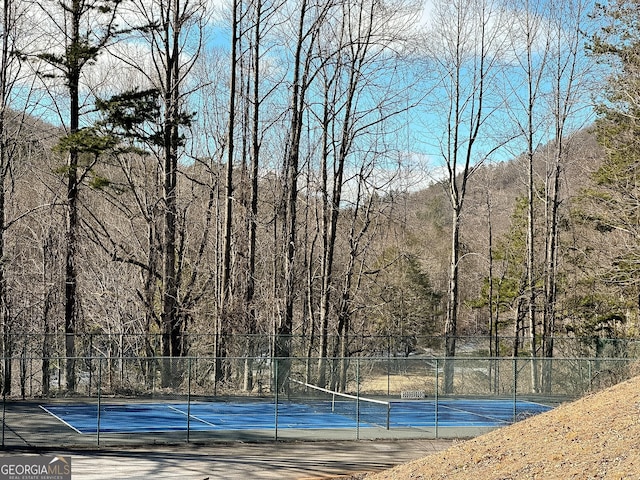 view of swimming pool with tennis court