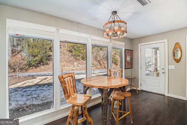 dining area featuring a wealth of natural light, dark hardwood / wood-style flooring, and a chandelier