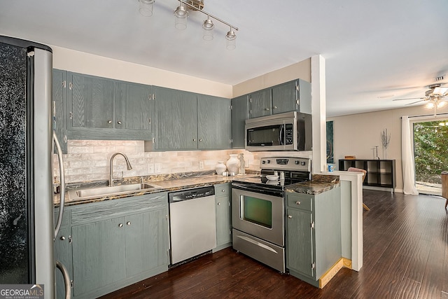 kitchen with dark hardwood / wood-style flooring, stainless steel appliances, sink, backsplash, and ceiling fan