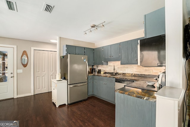 kitchen featuring dark wood-type flooring, sink, backsplash, gray cabinets, and stainless steel refrigerator