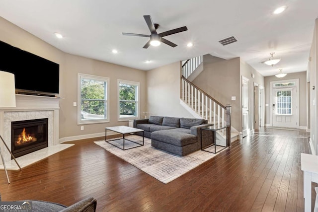 living room featuring ceiling fan, a wealth of natural light, a fireplace, and hardwood / wood-style floors