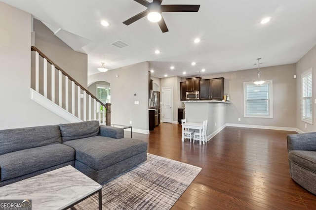 living room featuring ceiling fan and dark hardwood / wood-style flooring