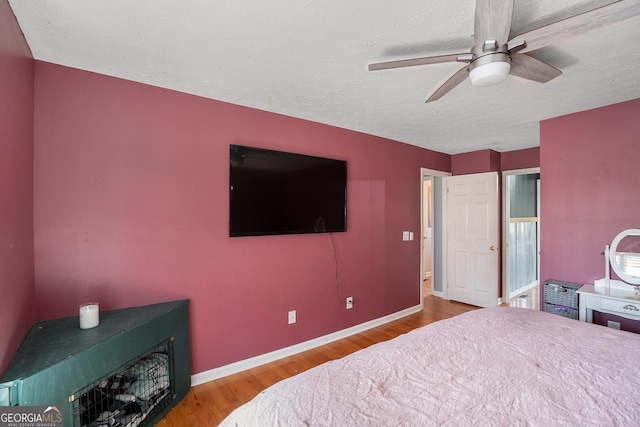 bedroom featuring ceiling fan, a textured ceiling, and light wood-type flooring