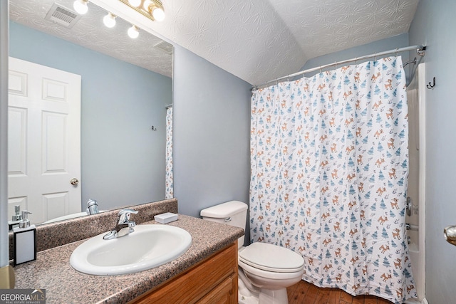 bathroom with vanity, hardwood / wood-style flooring, toilet, and a textured ceiling