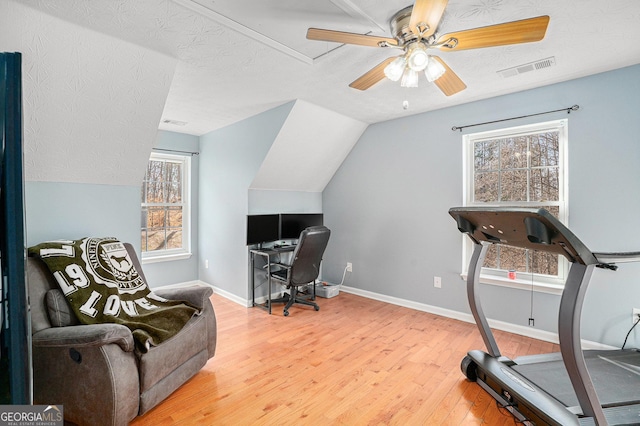 office featuring ceiling fan, lofted ceiling, hardwood / wood-style floors, and a textured ceiling