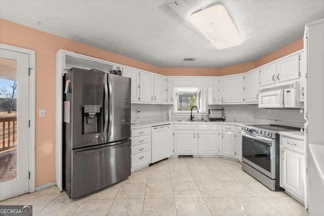 kitchen with sink, white cabinetry, appliances with stainless steel finishes, and a healthy amount of sunlight