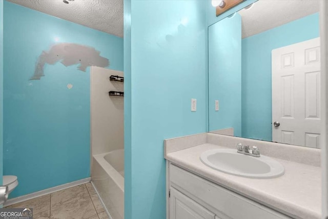 bathroom with a textured ceiling, tile patterned floors, vanity, and toilet