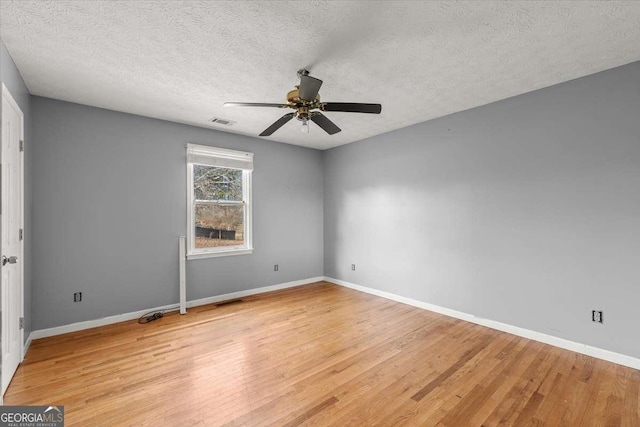 spare room featuring a textured ceiling, ceiling fan, and light hardwood / wood-style floors