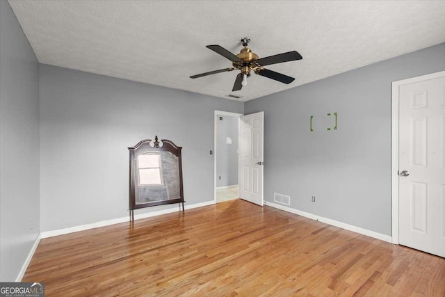 unfurnished room featuring ceiling fan, a textured ceiling, and light hardwood / wood-style floors