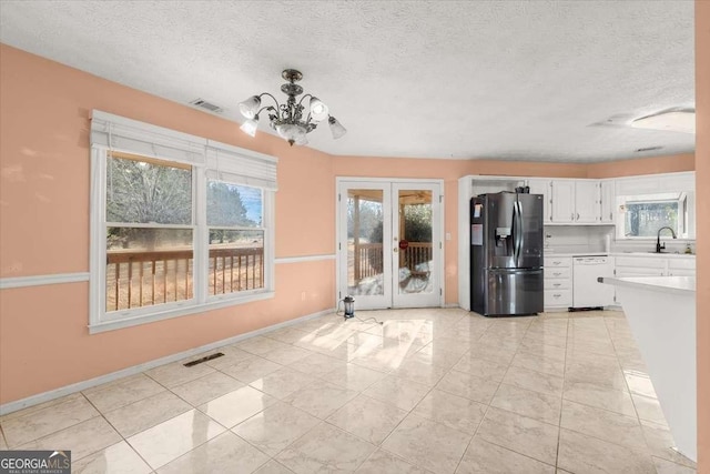 kitchen with white cabinets, dishwasher, an inviting chandelier, sink, and stainless steel fridge with ice dispenser