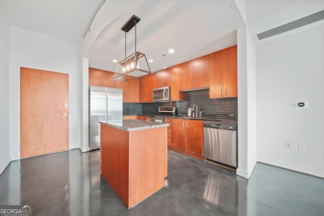 kitchen with appliances with stainless steel finishes, a kitchen island, sink, backsplash, and hanging light fixtures