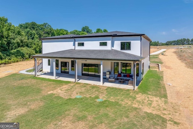 rear view of house featuring a yard, an outdoor living space, and a patio