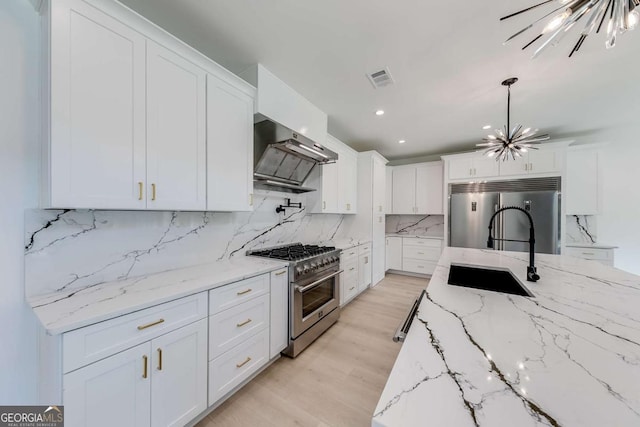 kitchen featuring extractor fan, tasteful backsplash, a notable chandelier, high quality appliances, and white cabinets