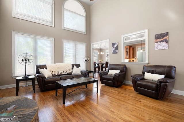 living room with hardwood / wood-style floors and a towering ceiling