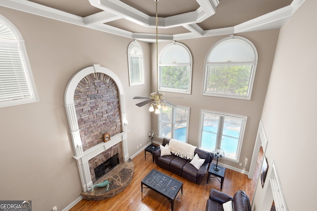 living room featuring hardwood / wood-style flooring, ornamental molding, and ceiling fan