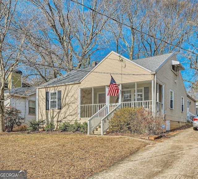 view of front of property featuring a front lawn and a sunroom