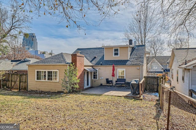 rear view of house with a patio area and a lawn