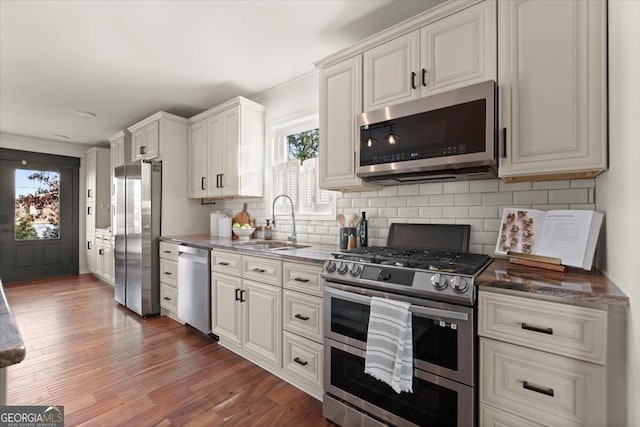 kitchen with stainless steel appliances, decorative backsplash, dark hardwood / wood-style flooring, white cabinets, and sink