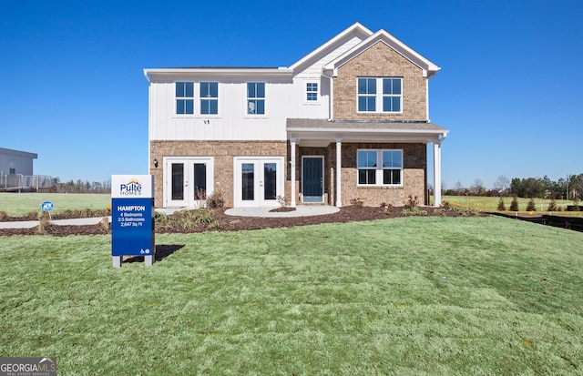 view of front of home with a front yard and french doors