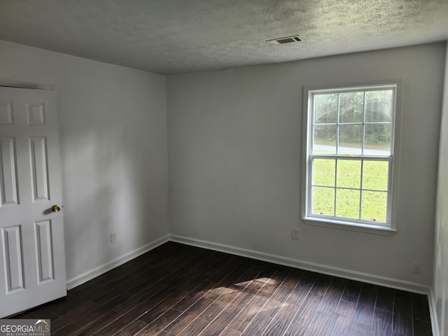 unfurnished room with dark hardwood / wood-style flooring and a textured ceiling