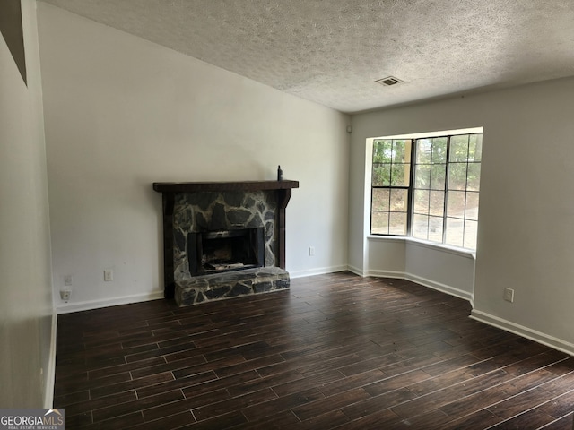 unfurnished living room featuring a textured ceiling and a stone fireplace