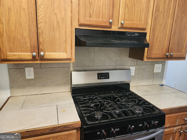 kitchen featuring tile countertops, stainless steel gas stove, and tasteful backsplash