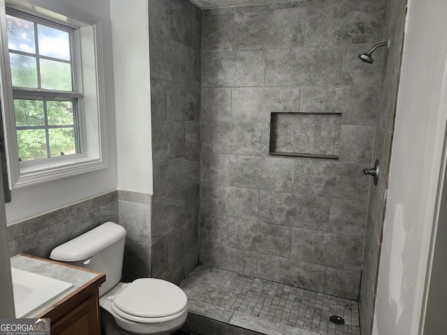 bathroom featuring toilet, a tile shower, and a healthy amount of sunlight