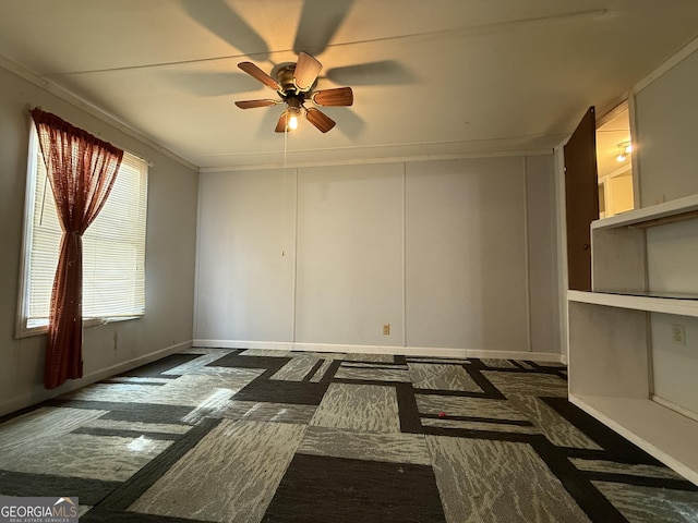 unfurnished room with ceiling fan, ornamental molding, and baseboards