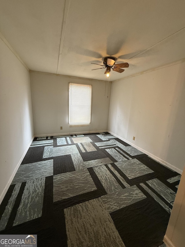 empty room featuring ceiling fan and baseboards