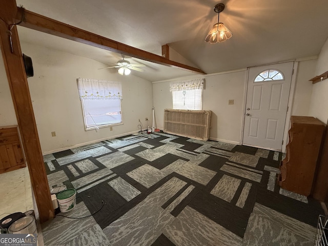 entrance foyer featuring vaulted ceiling with beams, baseboards, and a ceiling fan