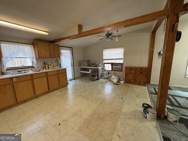 kitchen with lofted ceiling with beams, a sink, a healthy amount of sunlight, light countertops, and light floors