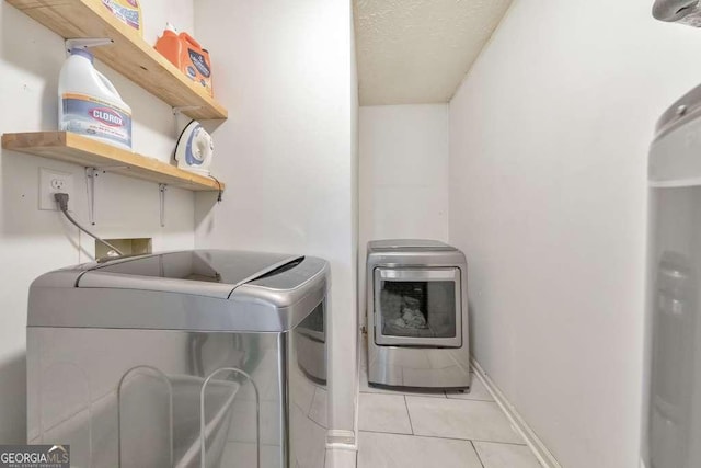 laundry room featuring light tile patterned floors and washer and clothes dryer