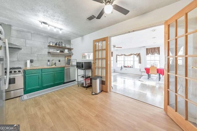 kitchen featuring light hardwood / wood-style floors, backsplash, appliances with stainless steel finishes, and french doors