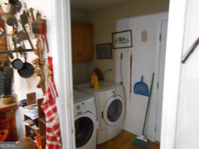 clothes washing area featuring separate washer and dryer and cabinets