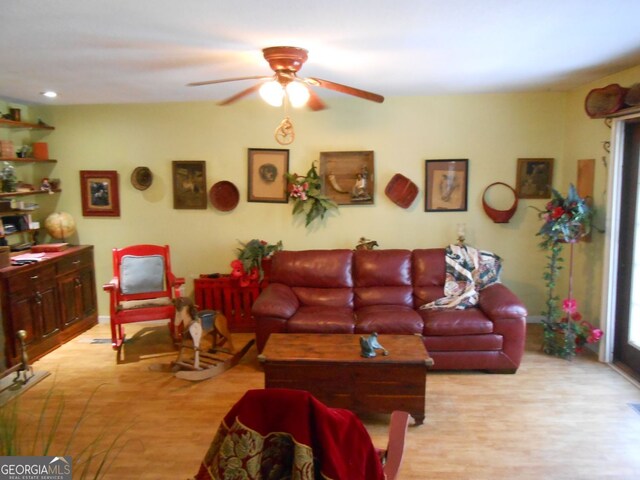 living room with ceiling fan and light hardwood / wood-style flooring