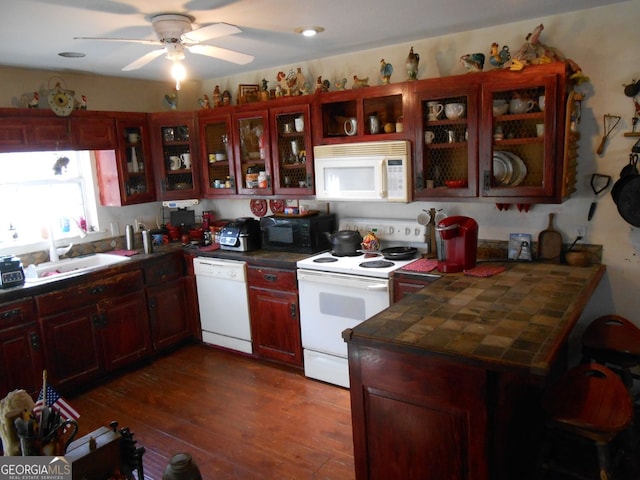 kitchen with ceiling fan, sink, white appliances, dark wood-type flooring, and tile counters