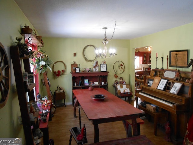 dining area featuring wood-type flooring and a notable chandelier