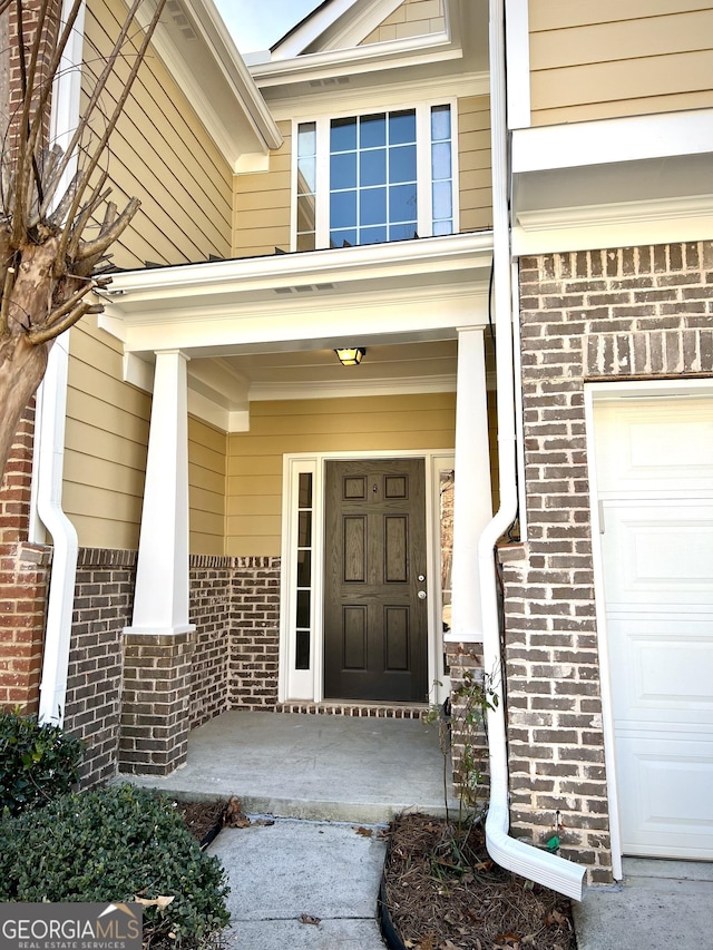 entrance to property with a garage and a porch