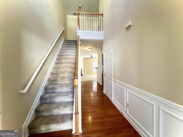 stairs with ceiling fan and hardwood / wood-style floors