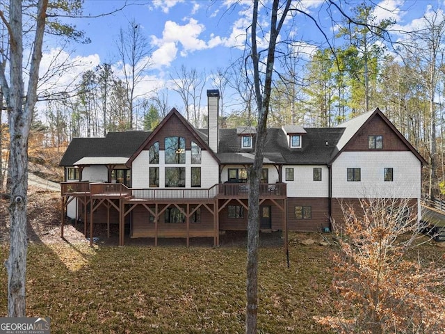 back of property with a chimney and a wooden deck