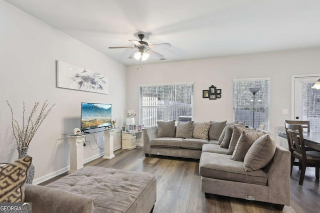 living room featuring dark wood-type flooring and ceiling fan