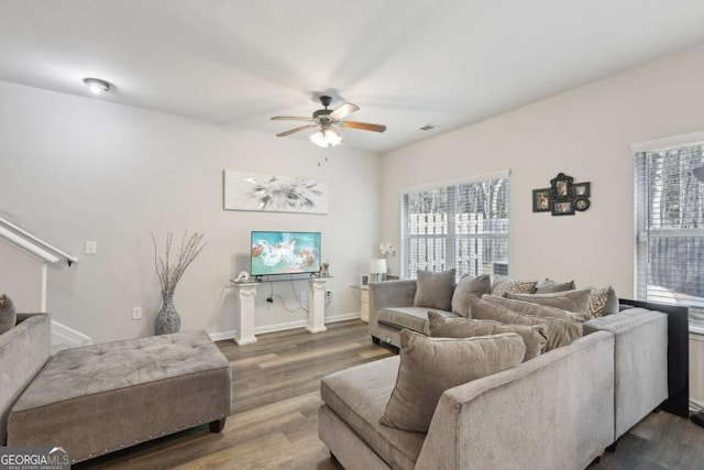 living room featuring ceiling fan and dark hardwood / wood-style floors